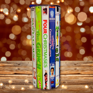 A 20 oz stainless steel insulated Christmas Movie Tumbler featuring a colorful design with movie covers including The Santa Clause, The Grinch, Four Christmases, National Lampoon Christmas Vacation and Elf. Comes with a clear lid, metal straw, and straw cleaner, perfect for hot and cold drinks.