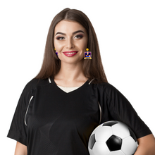 Load image into Gallery viewer, A girl smiling and holding a soccer ball wearing Ted Lasso earrings
