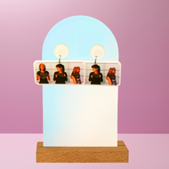 Earrings featuring mugshot photos of Peyton Brooke and Haley from One Tree Hill, featured on a pink background