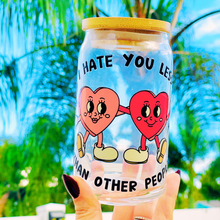 Load image into Gallery viewer, A 16 oz glass cup featuring a UVDTF wrap with two hand-holding hearts and the phrase “I Hate You Less Than Other People.” Comes with a bamboo lid and reusable glass straw, perfect for cold drinks. BPA-free and handwash only.
