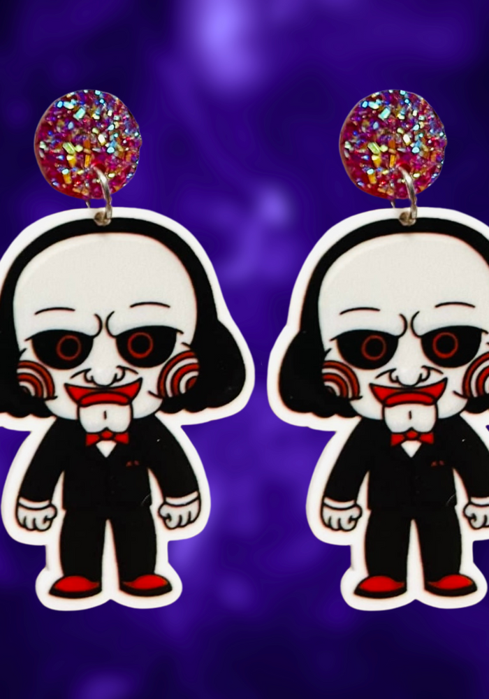 Cute cartoon Jigsaw earrings inspired by the Saw movies, ideal for fans of horror and playful Halloween style.