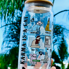 Load image into Gallery viewer, A 20 oz glass cup featuring colorful cat illustrations and Taylor Swift album-inspired designs, with the phrase &quot;Karma is a Cat,&quot; paired with a bamboo lid and glass straw. Perfect for Swifties and cold drink lovers.
