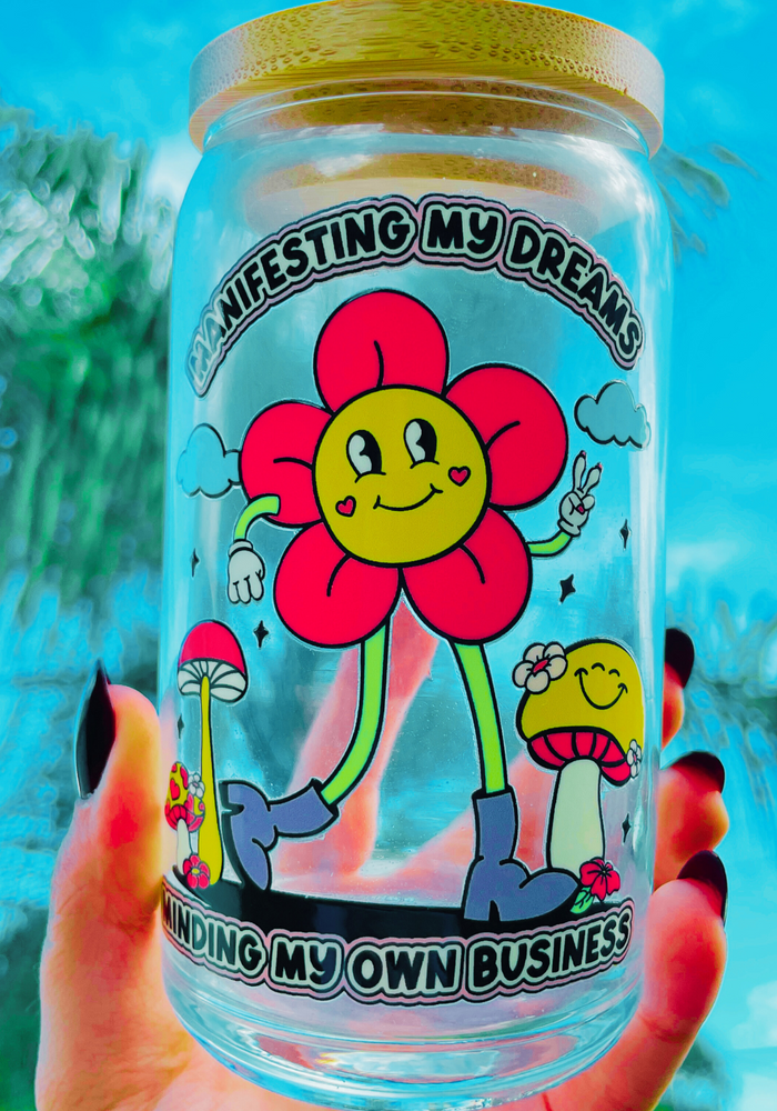 A 20 oz glass cup with a vibrant flower design that reads 