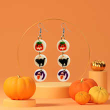 Load image into Gallery viewer, Earrings featuring mini replicas of Pillsbury Halloween sugar cookies, including jack-o&#39;-lanterns, black cats, and ghosts, dangling from hooks against an orange background. Perfect for Halloween nostalgia and fun fall fashion.
