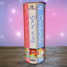 Load image into Gallery viewer, A 20 oz stainless steel insulated tumbler featuring a vibrant design with vintage Disney princess VHS covers, including Alice in Wonderland, Snow White and the Seven Dwarfs, and Cinderella. Comes with a clear lid, metal straw, and straw cleaner, perfect for hot and cold drinks.
