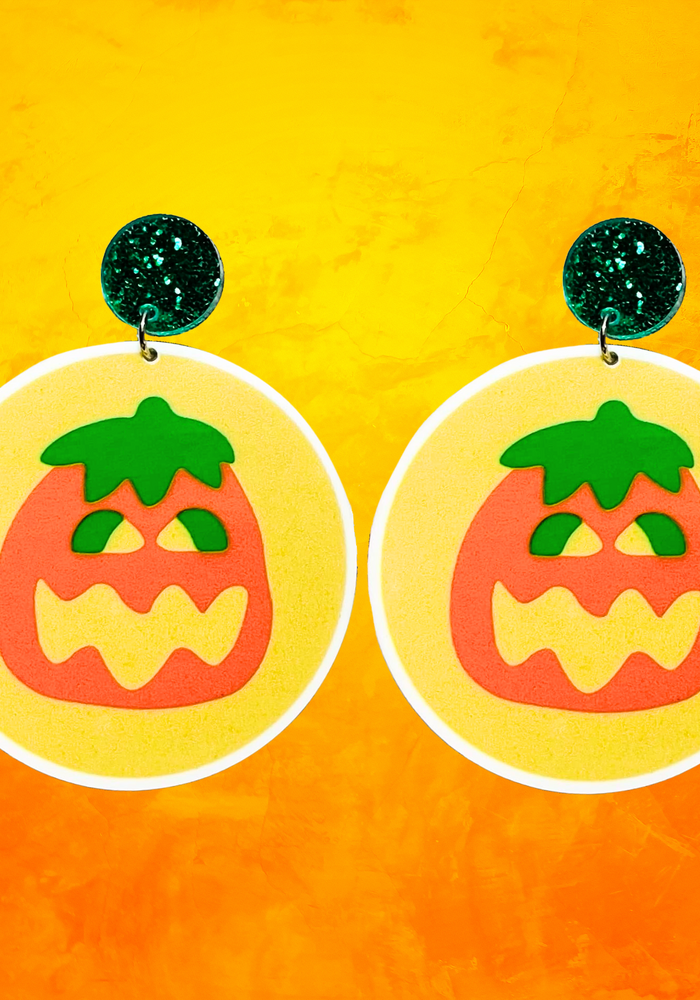 Earrings shaped like Pillsbury Halloween cookies with a pumpkin image on top, perfect for fans of nostalgic fall treats and Halloween accessories