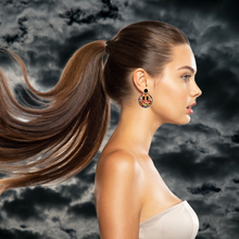 Load image into Gallery viewer, A model standing in front of a cloudy sky wearing smiley face earrings filled with colorful ghosts and flowers, perfect for a fun and lighthearted Halloween look
