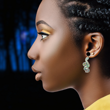 Load image into Gallery viewer, A model posed in front of an evening sky, showing off her silver snake earrings 
