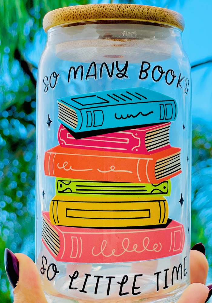 A 16oz BPA-free glass cup with a UVDTF wrap featuring colorful stacked books and the phrase 
