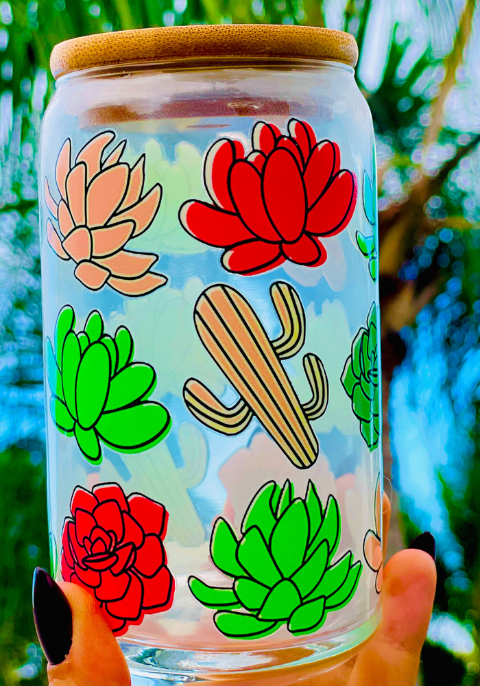 A 16 oz glass cup featuring a colorful succulent and cactus design with a bamboo lid and reusable glass straw. Perfect for cold drinks, eco-friendly, and BPA-free. Handwash only.
