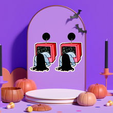 Load image into Gallery viewer, Purple jewelry holder with earrings featuring a cartoon-style figure climbing out of a TV, inspired by The Ring, perfect for fans of horror movies and unique Halloween accessories.
