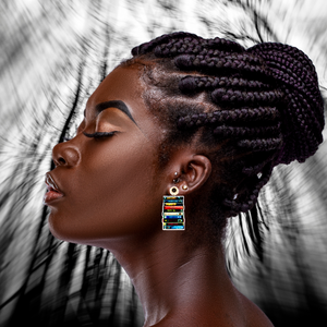 A model in front of a warped forest backdrop wearing earrings with a stack of classic cult horror VHS tapes, including Brain Damage, Firestarter, and Chopping Mall, ideal for fans of vintage horror movies.