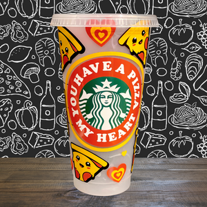 A 16 oz reusable Starbucks-compatible cold cup with a marble-changing design that shifts to orange, red, and blue when filled with cold liquid. The cup features a playful vinyl wrap reading "You Have a Pizza My Heart" and comes with a clear plastic lid and reusable straw, ideal for iced coffee lovers.